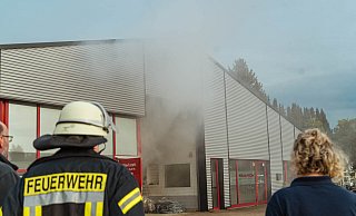 Der Kunstnebel steigt aus der Lagerhalle empor. Rechts beobachtet Einheitsführerin Melanie Mengedoht das Geschehen. - Leon Stock/FreitagTV