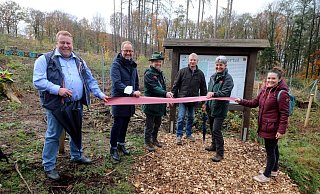 Abbildung: Schnitten gemeinsam das Band zur Einweihung des Bürgerwaldes in Extertal-Bösingfeld durch (v.l.): Manfred Stoller (damaliger Vorsitzender des Umwelt-, Energie- und Betriebsausschuss der Gemeinde), Jörg Düning-Gast (Verbandsvorsteher), Thomas Fritzemeier (Revierförster), Frank Meier (Bürgermeister Extertal), Susanne Hoffmann (Stellv. Leitung Forstabteilung) und Julia Stein (Geschäftsführerin Marketing Extertal e.V.). - Marketing Extertal