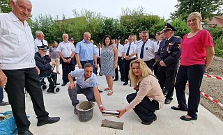 Ewa Hermann und Nicolai Stoll vom Bauamt der Gemeinde Kalletal setzen die Zeitkapsel ins Fundament des neuen Feuerwehrgerätehauses in Talle, während unter anderem dahinter Uwe Kordfunke (links) aus der Ehrenamtsabteilung der Feuerwehr, Bürgermeister Mario Hecker (hinter Nicolai Stoll), daneben Fachbereichsleiterin Ordnung und Soziales Andrea Batzer sowie Architektin Wera Binder (rechts). - Nadine Uphoff
