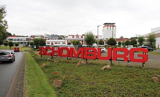 Auf dem Schomburg-Gelände soll neben der "Nolting"-Halle (rechts im Bild) eine neue Produktionshalle entstehen. Die Fläche befindet sich nicht im Bild. Den Mitarbeiter-Parkplatz (hinter dem Schriftzug) würde das Unternehmen gerne auf die andere Straßenseite verlegen. - Jana Beckmann Auf dem Schomburg-Gelände soll neben der "Nolting"-Halle (rechts im Bild) eine neue Produktionshalle entstehen. Die Fläche befindet sich nicht im Bild. Den Mitarbeiter-Parkplatz (hinter dem Schriftzug) würde das Unternehmen gerne auf die andere Straßenseite verlegen. - Jana Beckmann