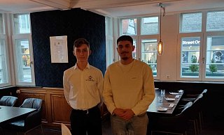 Tom Zink und Mohammad Besmar vor dem festlich eingedeckten Tisch. - Geschwister-Scholl-Gesamtschule Tom Zink und Mohammad Besmar vor dem festlich eingedeckten Tisch. - Geschwister-Scholl-Gesamtschule