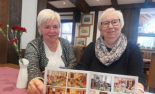 Hannelore Kreylos (rechts) wird die Leitung des Seniorentreffs im Februar nächsten Jahres an Annegret Peterseim abgeben. Die beiden Frauen zeigen Fotos der Seniorennachmittage. - Michaela Weiße