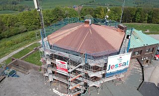 Auf dem Foto steht das Gerüst noch. Doch seit ein paar Tagen ist es abgebaut, das neue Kupferdach ist fertig und glänzt mit der Sonne um die Wette. - Julian Jessat