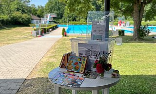 Gut sichtbar im Eingangsbereich des Freibades - hier in Schwarzenbrink - lädt die Bücherkiste der Stadtbibliothek zum Stöbern ein. - Stadt Detmold Gut sichtbar im Eingangsbereich des Freibades - hier in Schwarzenbrink - lädt die Bücherkiste der Stadtbibliothek zum Stöbern ein. - Stadt Detmold