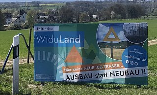Dieses große WiduLand-Plakat steht in Höhe der Stelle, wo eine ICE-Neubautrasse in den Obernberg geführt würde. Im Hintergrund ist die Siedlung Elkenbrede zu sehen. - Monika Prüßner-Claus Dieses große WiduLand-Plakat steht in Höhe der Stelle, wo eine ICE-Neubautrasse in den Obernberg geführt würde. Im Hintergrund ist die Siedlung Elkenbrede zu sehen. - Monika Prüßner-Claus