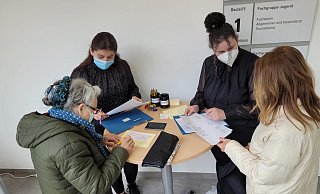 Ebru Birincioglu (Zweite von rechts) und ihre Kollegin Cigdem Önen haben zwei Schecks vorbereitet, die sie an ukrainische Flüchtlinge übergeben. Das Sozialamt Lage hatte schon kurz nach der Ankunft der ersten Flüchtlinge eine einfache Geldausgabe mit der Sparkasse am Markt organisiert. Es ist eine Aufgabe von vielen, die zusätzlich bewältigt werden müssen. - Astrid Sewing