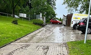 Wasser-, Schlamm- und Geröllmassen schieben sich den Zufahrtsweg hinunter und dringen in die Außenbereiche der Katzenstation ein. - Maria Toman
