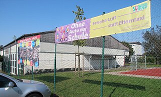 Die Grundschule In der Senne macht bereits mit Transparenten Eltern darauf aufmerksam, dass ihre Sprösslinge auch mal ein paar Meter zu Fuß gehen können und nicht mit dem Auto bis vor den Eingang gebracht werden müssen. - Dieter Asbrock