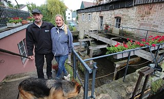 Christian Otto und Evelin Pieper vor der Langenholzhauser Wassermühle. Das Ehepaar will das im Jahr 2015 ausgebrannte Denkmal restaurieren. Den Außenbereich haben sie in Absprache mit den Denkmalschützern schon hergerichtet. - Jens Rademacher Christian Otto und Evelin Pieper vor der Langenholzhauser Wassermühle. Das Ehepaar will das im Jahr 2015 ausgebrannte Denkmal restaurieren. Den Außenbereich haben sie in Absprache mit den Denkmalschützern schon hergerichtet. - Jens Rademacher