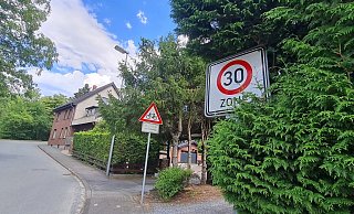 Das Tempo-30-Schild ist für Autofahrer hier kaum zu sehen, weil es fast zugewachsen ist. Auch das Verbotsschild für Lastwagen mit mehr als 7,5 Tonnen ist am Fuß der Feldbrandstraße kaum erkennbar. - Marianne Schwarzer Das Tempo-30-Schild ist für Autofahrer hier kaum zu sehen, weil es fast zugewachsen ist. Auch das Verbotsschild für Lastwagen mit mehr als 7,5 Tonnen ist am Fuß der Feldbrandstraße kaum erkennbar. - Marianne Schwarzer