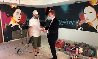 Knstler Elmar Lause und Christian Steffen vom Lippischen Hof besprechen das Wandmotiv.  - Sven Kienscherf