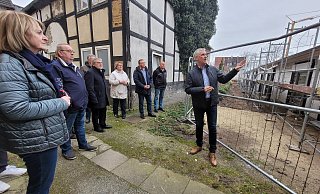 Das Fachwerkhaus links steht unter Denkmalschutz - auch wenn es dringend sanierungsbedürftig ist. In direkter Nachbarschaft wird ein Pflegeheim gebaut, ein schmaler Weg soll dazwischen in Richtung Lidl führen. Beigeordneter Thorsten Paulussen (rechts) erklärte die Situation, einige Mitglieder des Bau- und Planungsausschusses kritisierten die Enge. - Astrid Sewing