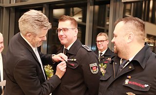 Sebastian Köster (Mitte) und Daniel Balke (rechts) sind seit 25 Jahren in der Feuerwehr aktiv. Im Auftrag des Innenministers heftet Bürgermeister Dirk Becker ihnen das Ehrenzeichen in Silber an. Im Hintergrund: Wehrführer Thomas Kronshage. - Knut Dinter Sebastian Köster (Mitte) und Daniel Balke (rechts) sind seit 25 Jahren in der Feuerwehr aktiv. Im Auftrag des Innenministers heftet Bürgermeister Dirk Becker ihnen das Ehrenzeichen in Silber an. Im Hintergrund: Wehrführer Thomas Kronshage. - Knut Dinter