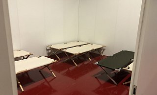 In der Messehalle stehen Pritschen in einem mit Trennwänden errichteten Raum. - Sven Kienscherf
