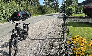 Wo die Roteiche von dem bewaldeten Grundstück (links) auf den Zaun gefallen ist, hat sie Spuren hinterlassen. Der Zaun ist noch nicht repariert. Auf der Kiesfläche stand der BMW, der bei dem Ereignis total demoliert wurde. - Silke Buhrmester