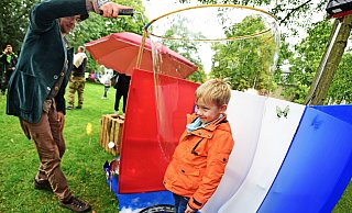 Julian lässt sich von Marco Frezzato im Schlosspark komplett in eine Seifenblase einhüllen Foto: Nicole Ellerbrake - Nicole Ellerbrake