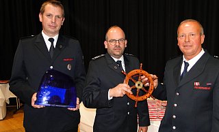Der neue Wehrführer Andreas Jakoby (Mitte) übernimmt das Steuer vom bisherigen Feuerwehr-Chef Jörg Diekmann (links). Der neue Stellvertreter Michael Pape (rechts) hält unterdessen das Blaulicht für Diekmanns neues Wohnmobil.  - Hajo Gärtner