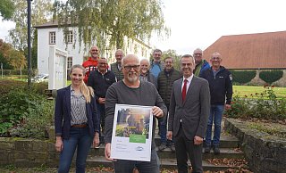Bürgermeister Jörg Bierwirth (vorne rechts) übergibt gemeinsam mit Westenergie-Kommunalmanagerin Maria Kemker die Urkunde an Dirk Steinmeier, Sprecher der LTG. Darüber freuen sich auch die weiteren Mitglieder der Gruppe: Uli Göke (hinten von links), Oliver Bruns, Uwe von Glembotzki, Fritz Loke, Dieter Vogel, Klaus Föste, Jürgen Koch und Dirk Vogel. - Michaela Weiße Bürgermeister Jörg Bierwirth (vorne rechts) übergibt gemeinsam mit Westenergie-Kommunalmanagerin Maria Kemker die Urkunde an Dirk Steinmeier, Sprecher der LTG. Darüber freuen sich auch die weiteren Mitglieder der Gruppe: Uli Göke (hinten von links), Oliver Bruns, Uwe von Glembotzki, Fritz Loke, Dieter Vogel, Klaus Föste, Jürgen Koch und Dirk Vogel. - Michaela Weiße