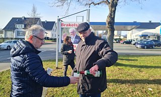 Ein Sektschlückchen zu Ehren des alten und neuen Bundespräsidenten: Dietmar Köller schenkt Uwe von Glembotzki ein. Im Hintergrund Dr. Inga Kretschzmar vor dem Plakat, das die Dorfgemeinschaft gestern nach der Wahl aufgestellt hat: "Brakelsiek ist stolz auf Dich!" - Marianne Schwarzer(LZ)