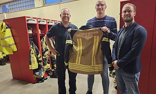 Wehrleiter Benjamin Brinkmeyer, Pressesprecher Carlos Hummerjohann und Fachgruppenleiter Malte Begemann zeigen eine Testjacke. Weil sie rundum mit Reflektorstreifen vershen ist, entfällt die Pflicht, Warnwesten zu tragen. - Astrid Sewing