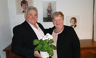 Brigitte und Giovanni Barbarito vor der Enkel-Fotowand. An ihrem goldenen Hochzeitstag können sie zufrieden auf ein gutes Leben zurückblicken. - Hajo Gärtner