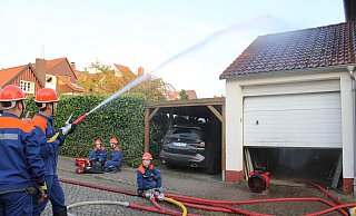 Im hohen Bogen löscht die Jugendfeuerwehr Blomberg den simulierten Garagenbrand und versorgt die "verletzte" Person. - Chiara Wibbeke