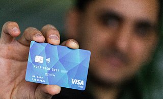 So könnte sie demnächst auch in Nordrhein-Westfalen aussehen: Ein Geflüchteter hält eine Debitcard in der Hand. +++ dpa-Bildfunk +++ - picture alliance/dpa