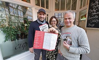 Ahmet Pehlivan (links)und Pia Pehlivan vom "Café Cup" organisieren den aktuellen "Ohrenschmaus". Hauptsponsor Wolfgang Meyer (Haus der Musik) hat noch schnell die frisch gedruckten Flyer zum Pressegespräch vorbei gebracht. - Jost Wolf
