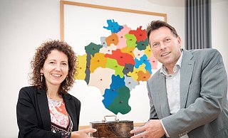 Kämmerin Dr. Miriam Mikus bekommt von Bürgermeister symbolisch die Stadtkasse überreicht. - Stadt Detmold Kämmerin Dr. Miriam Mikus bekommt von Bürgermeister symbolisch die Stadtkasse überreicht. - Stadt Detmold