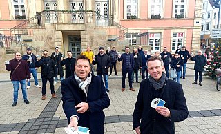 Bürgermeister Frank Hilker (links) und Round table-Präsident Julian Hilker halten die ersten Kartensets des neuen Gastro-Quartetts in den Händen. Im Hintergrund haben sich viele der beteiligten Gastronomen versammelt. - Janet König Bürgermeister Frank Hilker (links) und Round table-Präsident Julian Hilker halten die ersten Kartensets des neuen Gastro-Quartetts in den Händen. Im Hintergrund haben sich viele der beteiligten Gastronomen versammelt. - Janet König