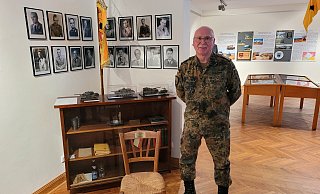 Oberstabsfeldwebel Günter Schlüter neben dem Stuhl, auf dem Generalfeldmarschall Rommel während des Halts vor Dünkirchen saß. - Raffael Giebel