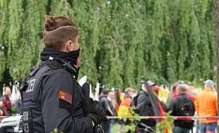 Ein Polizeibeamter beobachtet während des Berufungsprozesses am Mittwoch die Kellner-Anhänger auf dem Kaiser-Wilhelm-Platz. Danach ging es für einige davon zur privaten "After-Show-Party" nach Tintrup. - Janet König