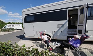 Karin Arnd-Egger und Jürgen Koch genießen die Sonne auf dem neuen Wohnmobil-Stellplatz. Im Hintergrund steht das Wohnmobil von Frank Möller, der auch nur Lob für den Stellplatz übrig hat. - Jost Wolf Karin Arnd-Egger und Jürgen Koch genießen die Sonne auf dem neuen Wohnmobil-Stellplatz. Im Hintergrund steht das Wohnmobil von Frank Möller, der auch nur Lob für den Stellplatz übrig hat. - Jost Wolf