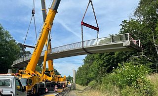 Am 25. Juni wurde die 110 Tonnen schwere Brücke von zwei Kränen neben der Fahrbahn der B1 abgelegt - Ralph Meyer