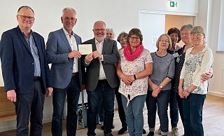 Michael Krügermeyer-Kalthoff (von links) und Thomas Kleinegees übergeben an Pastor Richard Krause und den Mitarbeiterinnen der Lagenser Mahlzeit einen Scheck in Höhe von 4000 Euro. - Lions Club Lage/Lippe
