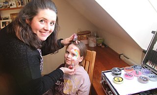 Step 4 Regenbogen: Zum Schluss noch Glitzer um den Regenbogen herum auf das Gesicht auftragen. - Nadine Uphoff