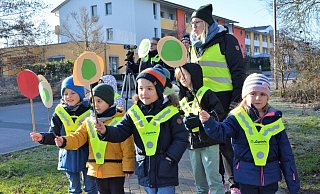 Die neue Kita-Leiterin Lena Siekmann steht hinter den Kindern. Die halten, je nachdem, ob ein Autofahrer die Geschwindigkeit eingehalten hat oder nicht, ihre Kellen mit grünem oder rotem Punkt nach oben. - Karin Prignitz