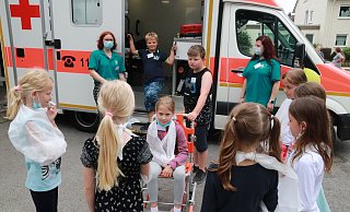 Am Ende des Kennenlerntags beim Deutschen Roten Kreuz wirken die neun Kinder mit den angelegten Dreieckt&uuml;chern wie lauter Verletzte. - Knut Dinter