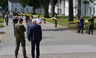 Brigadegeneral Marco Eggert und der Augustdorfer Bürgermeister Thomas Katzer beobachten, wie das vom Kasernentor kommende gelbe Band mit Unterstützungsbekundungen langsam die gemeinsame Heimgesellschaft erreicht. - Jost Wolf