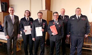 Leiter der Feuerwehr Mike Mundhenke (rechts) und Bürgermeister Jörg Bierwirth (links) gratulieren den Geehrten, die der Wehr schon viele Jahre die Treue halten. - Rudi Rudolph
