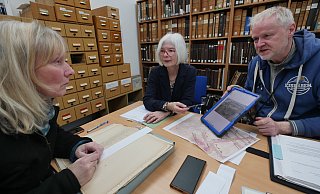 Robert Gündchen (Archäologe) zeigt Dr. Bärbel Sunderbrink (Stadtarchiv, links) und Dr. Elke Treude (Landesmuseum) ein Foto von der Grabung in der Langen Straße. Mit Hilfe von Dokumenten des Stadtarchiv versuchen alle drei, den Fund einzuordnen. - Jost Wolf Robert Gündchen (Archäologe) zeigt Dr. Bärbel Sunderbrink (Stadtarchiv, links) und Dr. Elke Treude (Landesmuseum) ein Foto von der Grabung in der Langen Straße. Mit Hilfe von Dokumenten des Stadtarchiv versuchen alle drei, den Fund einzuordnen. - Jost Wolf