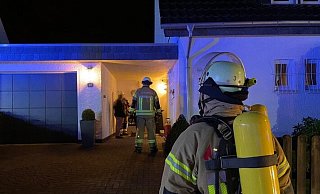 Vor dem Einfamilienhaus in der Straße "Am Steinbrink" stehen Feuerwehrleute. - Daniel Hobein / Feuerwehr Bad Salzuflen