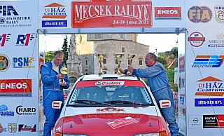 Im ungarischen Mecsek stellt der Fahrer Alfons Nothdurfter ein paar Pokale auf das Dach seines 300 PS starken Ford Sierra Cosworth (rechts). Jürgen Nolte schaut sich ihre eingravierten Namen an. Beide tragen Overalls, die eventuell ausbrechendem Feuer eine Minute lang standhalten müssen. - Fotorechte: Jürgen Nolte Im ungarischen Mecsek stellt der Fahrer Alfons Nothdurfter ein paar Pokale auf das Dach seines 300 PS starken Ford Sierra Cosworth (rechts). Jürgen Nolte schaut sich ihre eingravierten Namen an. Beide tragen Overalls, die eventuell ausbrechendem Feuer eine Minute lang standhalten müssen. - Fotorechte: Jürgen Nolte