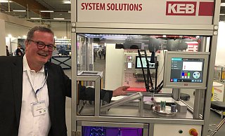 Keine Angst vor dem Roboterarm: Detlef Loest von der Firma KEB Automation (Barntrup) greift auf der Zuliefermesse Maschinenbau wortwörtlich in einen vollautomatischen Produktionsprozess ein. Der Roboterarm, der zuvor noch schwungvoll Spielchips verteilt hat, wird erst langsamer und stoppt dann gänzlich. „Gewarnt“ wird er vor der Menschenhand von zwei aufeinanderfolgenden Lichtschranken. - Thomas Reineke Keine Angst vor dem Roboterarm: Detlef Loest von der Firma KEB Automation (Barntrup) greift auf der Zuliefermesse Maschinenbau wortwörtlich in einen vollautomatischen Produktionsprozess ein. Der Roboterarm, der zuvor noch schwungvoll Spielchips verteilt hat, wird erst langsamer und stoppt dann gänzlich. „Gewarnt“ wird er vor der Menschenhand von zwei aufeinanderfolgenden Lichtschranken. - Thomas Reineke