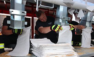 Frank Launhardt und Kameraden von der Feuerwehr Bad Salzuflen füllen Sand ab. - Kreis Lippe