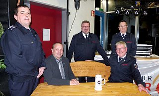 Udo Knaup (rechts) und Bürgermeister Mario Hecker probieren das sichtlich bequeme Geschenk gleich aus, dahinter stehen Michael Grüttemeier, Leiter der Feuerwehr mit den stellvertretenden Leitern der Feuerwehr Michael Little (links) und Arnd Plettemeier (rechts). - Rudi Rudolph