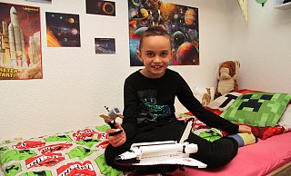 Der achtjährige Vincent sitzt in seinem Kinderzimmer. Er interessiert sich sehr für Astronomie und Raumfahrt. - Nadine Uphoff