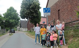 Steve Karkowski (links) und weitere Eltern möchten, dass sich die Autofahrer an der Istruper Kita in der Dorfstraße an die Geschwindigkeitsbegrenzung halten. Die Kita befindet sich links hinter dem schwarzen Auto im Hintergrund. - Karolina Schmidt