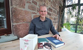 Philipp Schmidt-Rhaesa zeigt Buch, CD und Liederbuch zum 80. Geburtstag des 2015 verstorbenen Christof Stählin. Dieser leitete die einflussreiche Liedermacher-Schule "Sago". Der Name stand früher auf vielen Küchenschubladen - eine ist links im Bild zu sehen. - Jens Rademacher