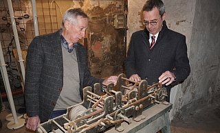Bürgermeister Jörg Bierwirth (rechts) und Ulrich Opel, Vorsitzender des Heimatvereins Schieder, schauen sich das alte Uhrwerk an. - Michaela Weiße